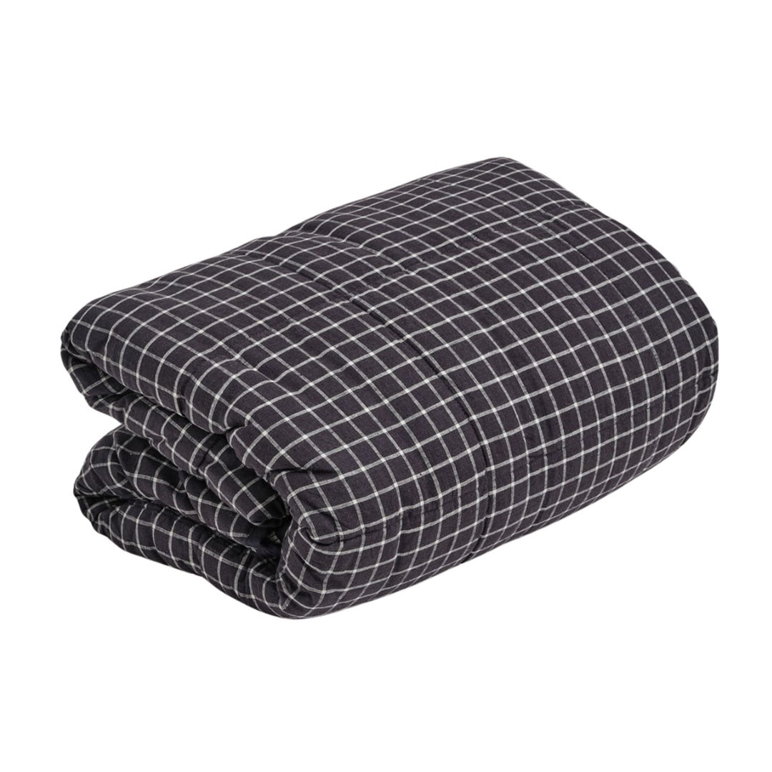 Folded navy and white checkered blanket on a white background