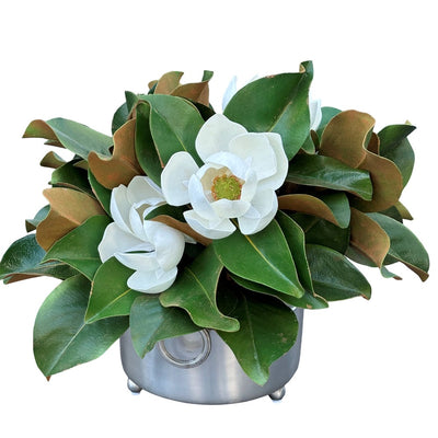 Magnolia flowers and foliage designed into a brushed silver vessel