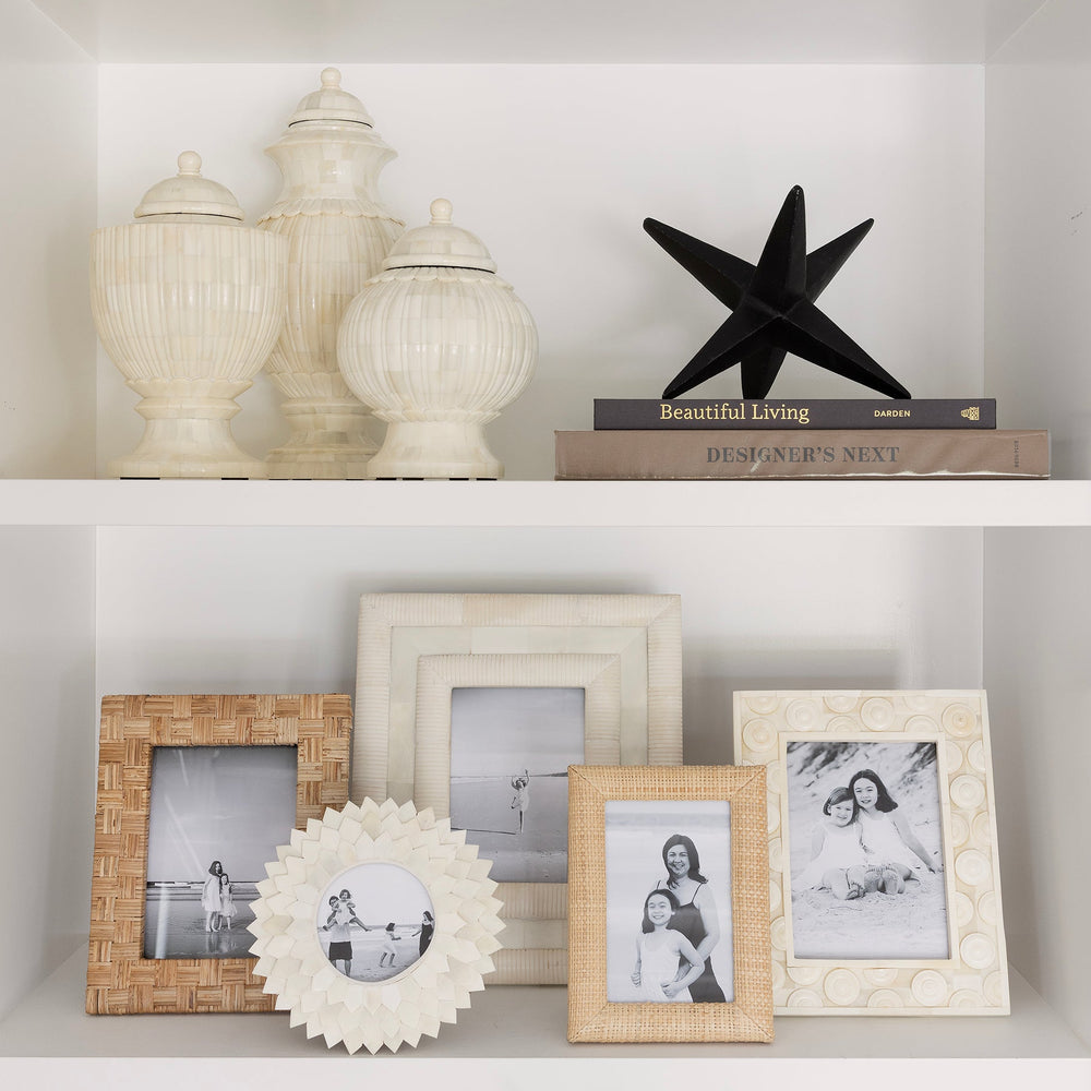 Decorative shelf with various items including framed photos, a starfish, and decorative vases.