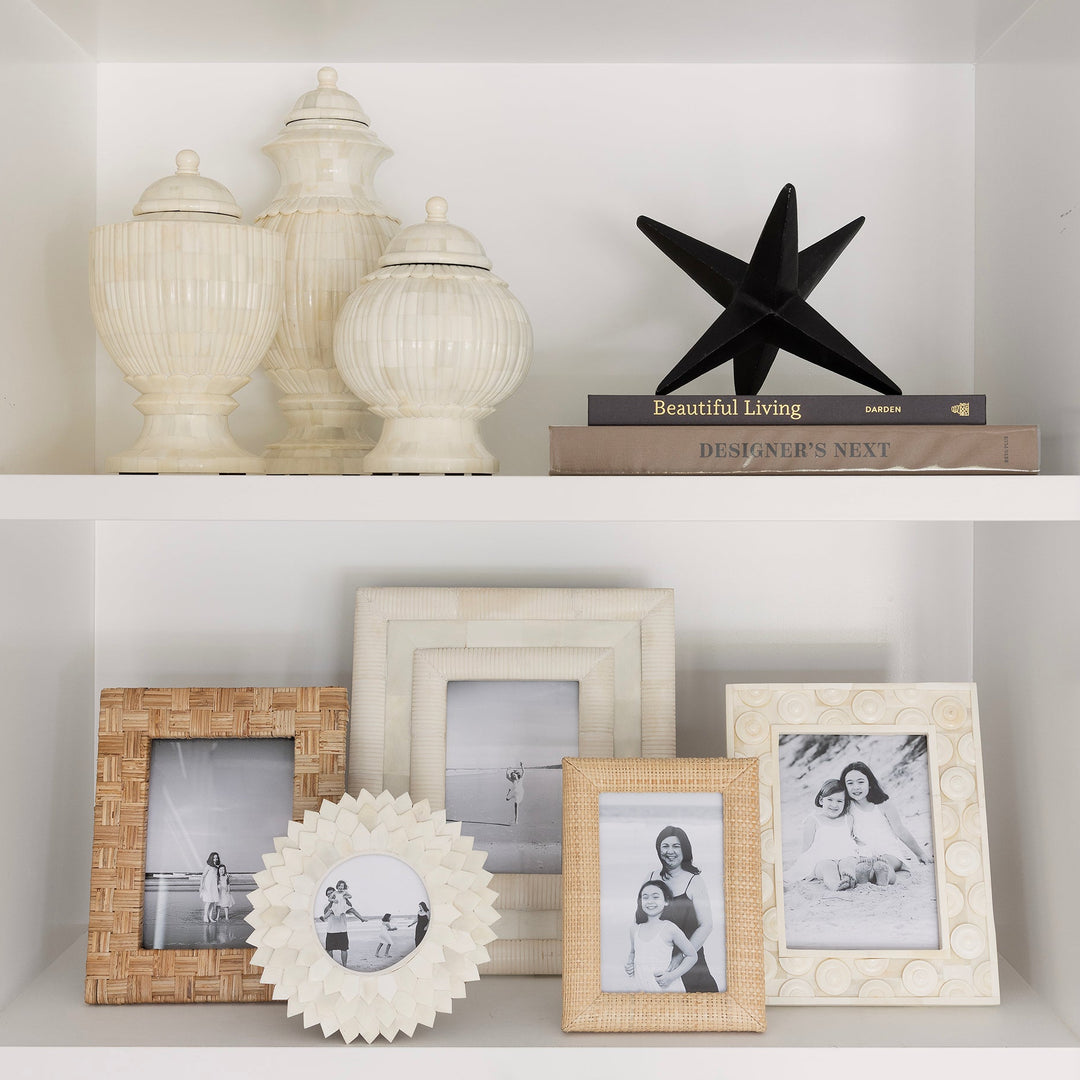 Decorative shelf with various items including framed photos, a starfish, and decorative vases.
