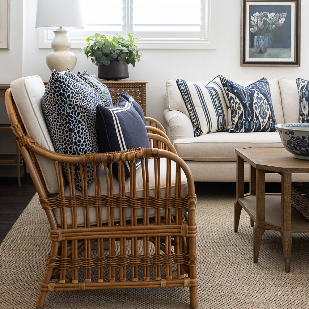 Two cape cod rattan armchairs in a lounge room setting. Styled with Indigo leopard print cushions and navy lumbar cushion. 
