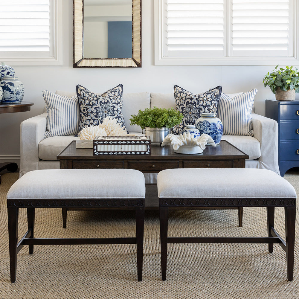 Two club benches sitting next to each other in a lounge room setting. Behind is a styled huxley coffee table and a neutral sofa with navy embroidered and a navy and white ticking stripe cushion. 