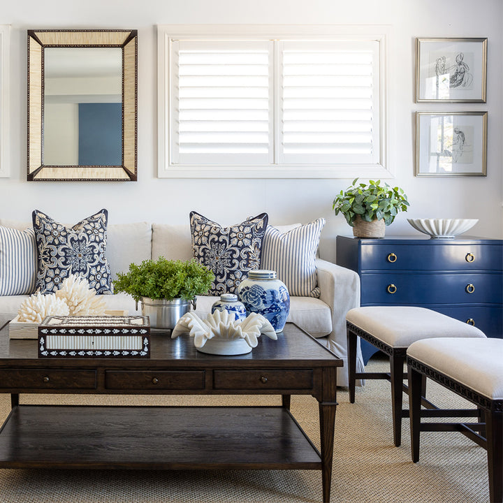 Two club benches sitting next to each other in a lounge room setting. Behind is a styled huxley coffee table and a neutral sofa with navy embroidered and a navy and white ticking stripe cushion. 