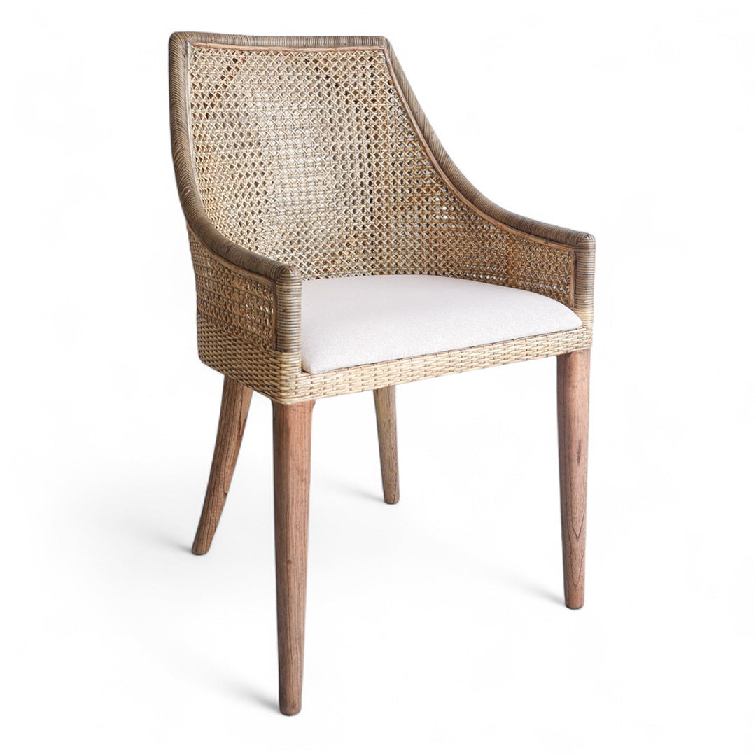 Woven Rattan dining chair with a neutral cushion on a white background