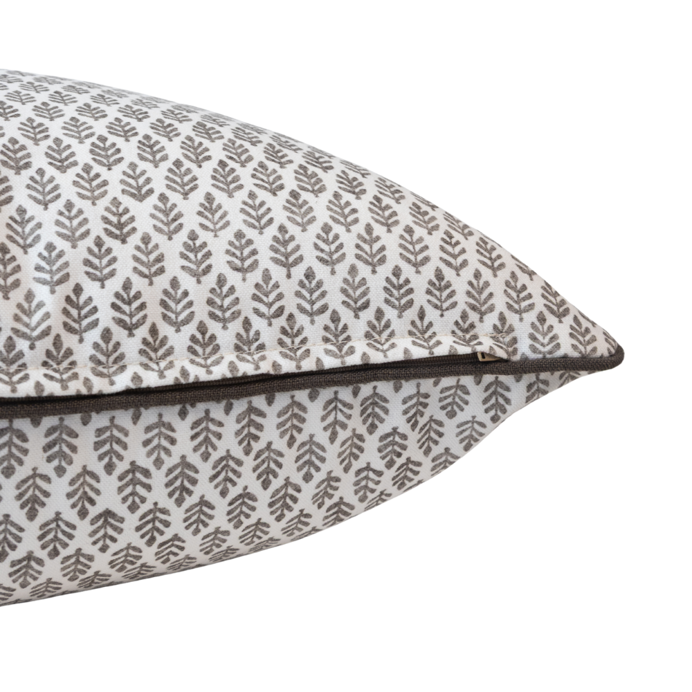 Zip detail on patterned pillow with leaf design on a white background