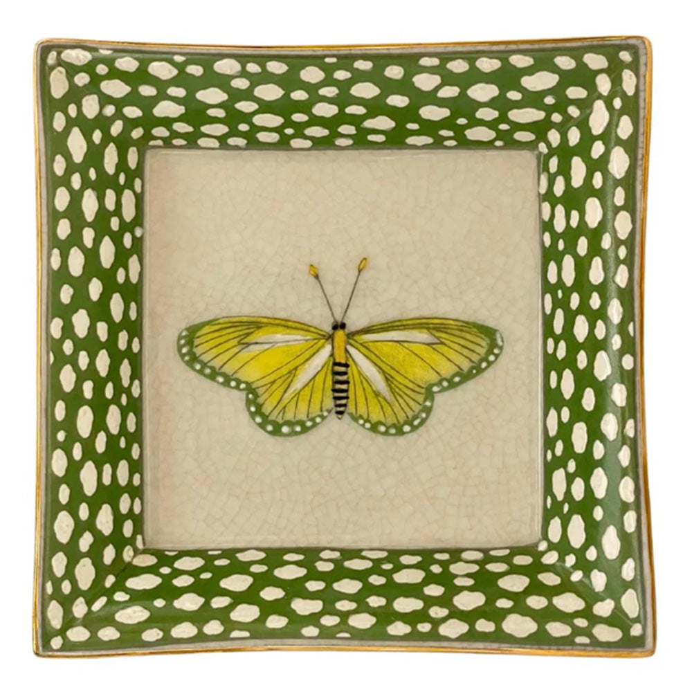 Decorative plate with a yellow butterfly design on a green and white polka dot border