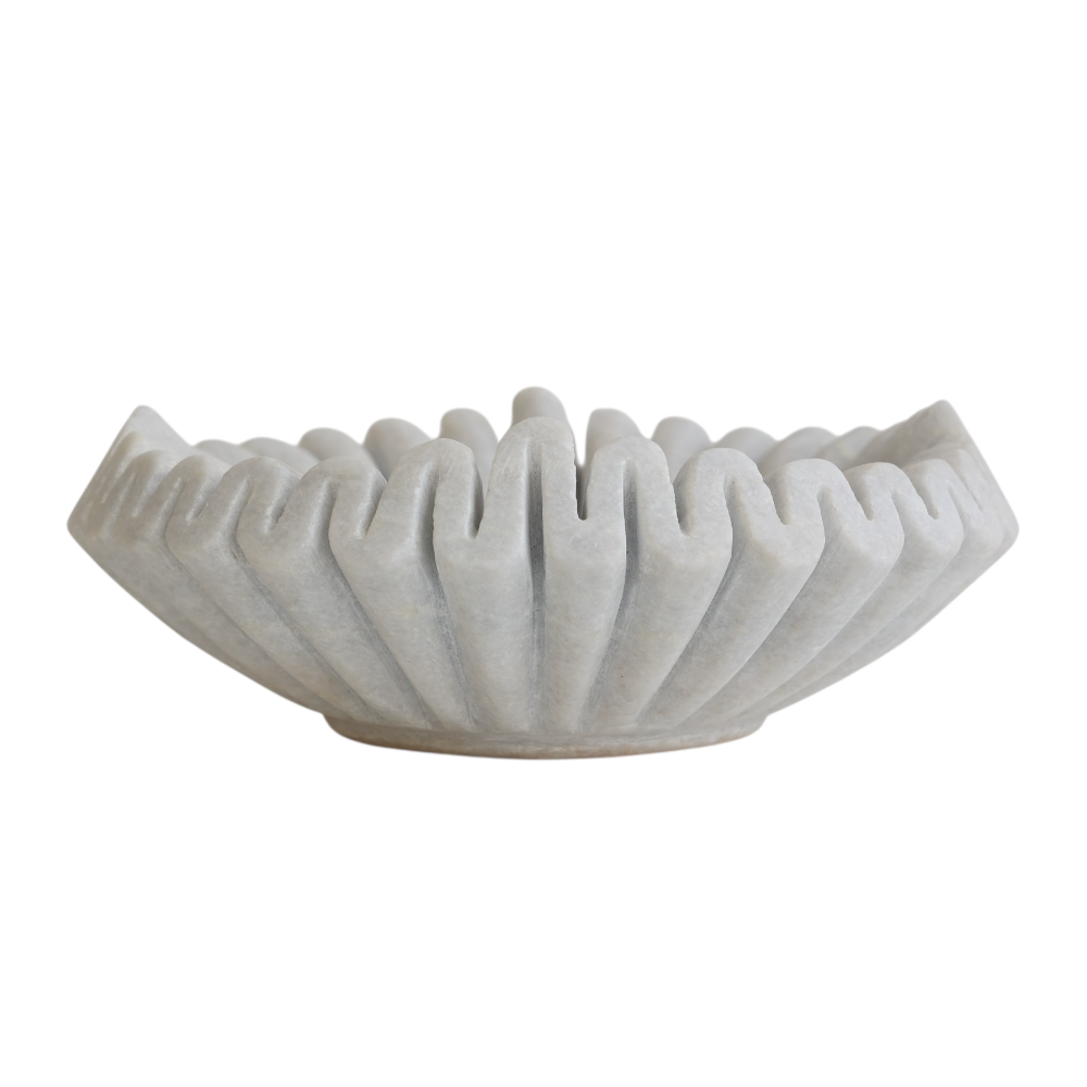 Decorative white marble bowl with ribbed texture on a white background