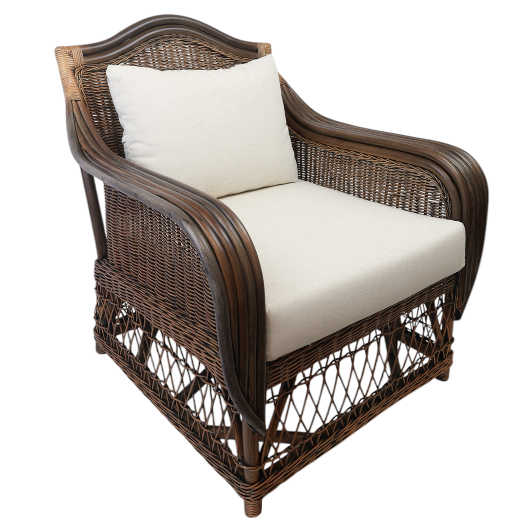 A dark brown rattan armchair with white cushions, featuring a sturdy silhouette with woven details and a padded seat and backrest.