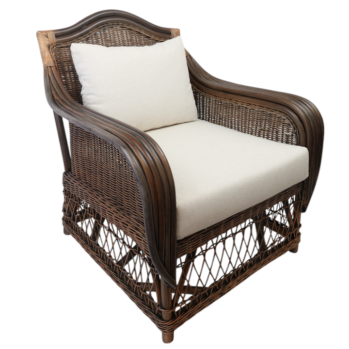 A dark brown rattan armchair with white cushions, featuring a sturdy silhouette with woven details and a padded seat and backrest.