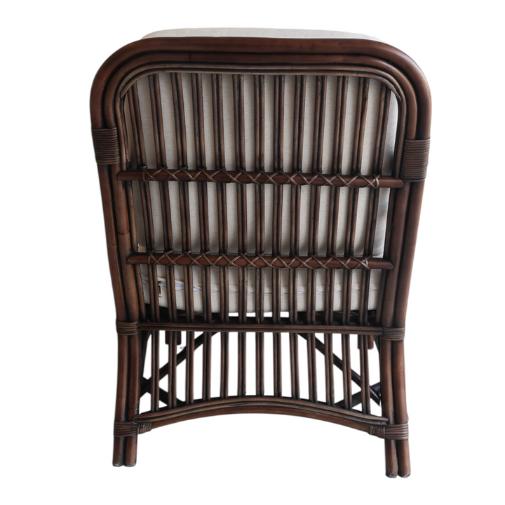 Back of rattan chair with striped cushion on a white background