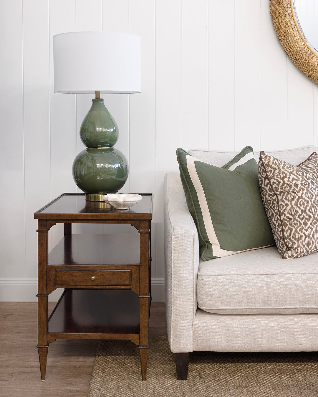 Living room with a beige sofa, decorative pillows, and a lamp on a side table.