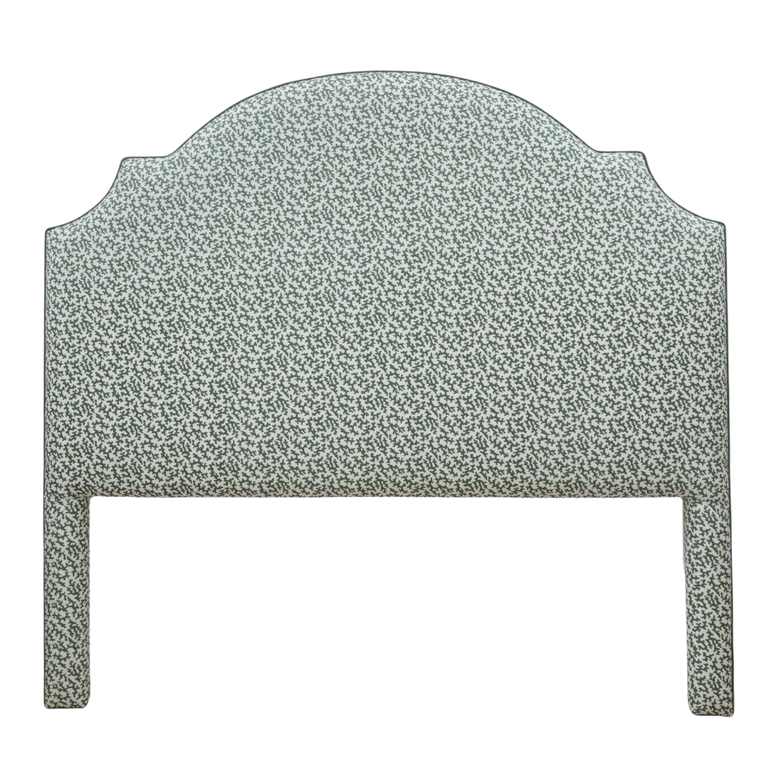 Green Seaweed print on white fabric upholstered bedhead on white background.