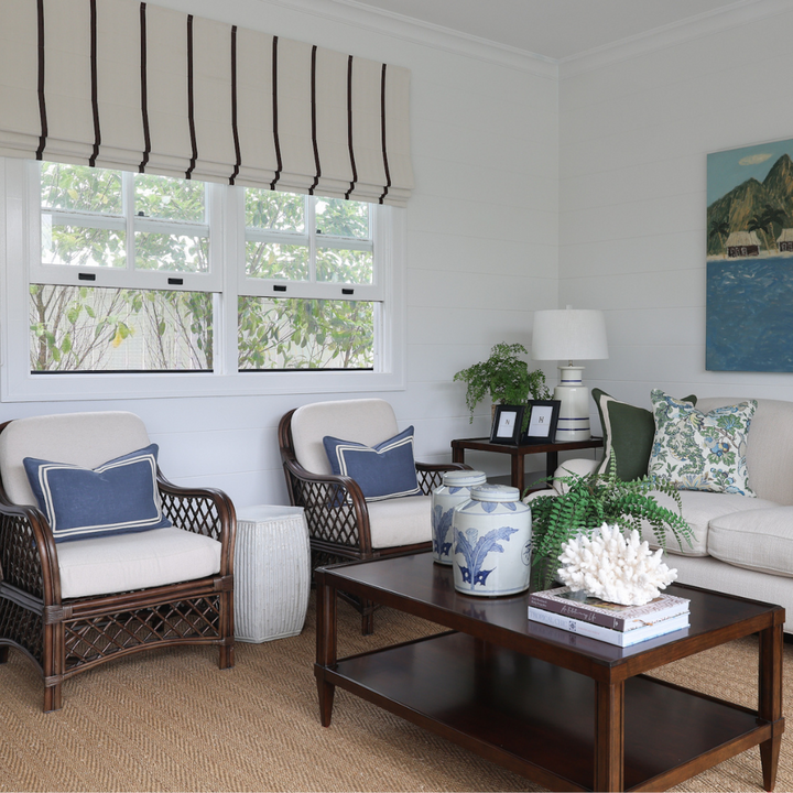Living room with wicker chairs, coffee table, and decorative items.