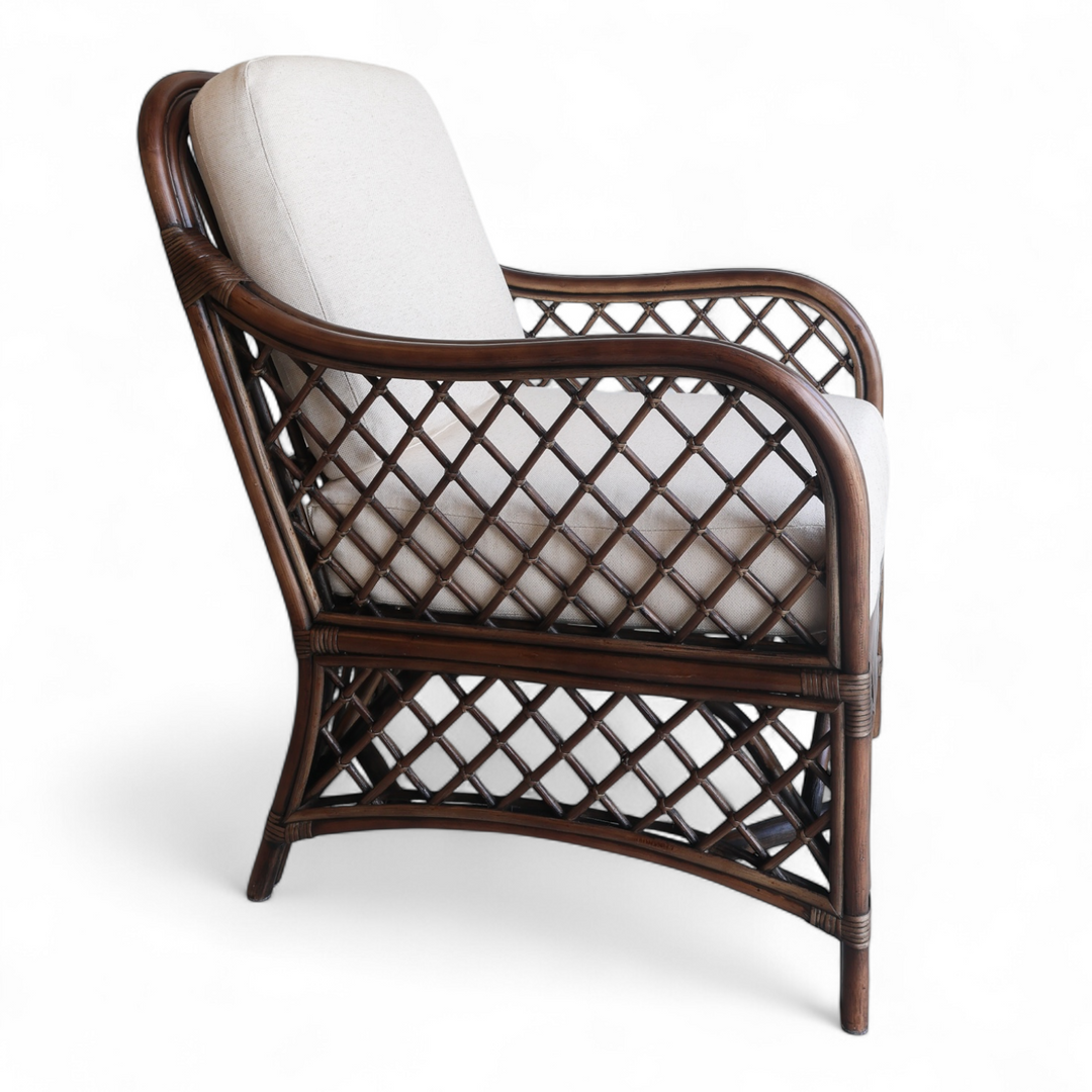 Side image of rattan armchair with white cushion on a white background
